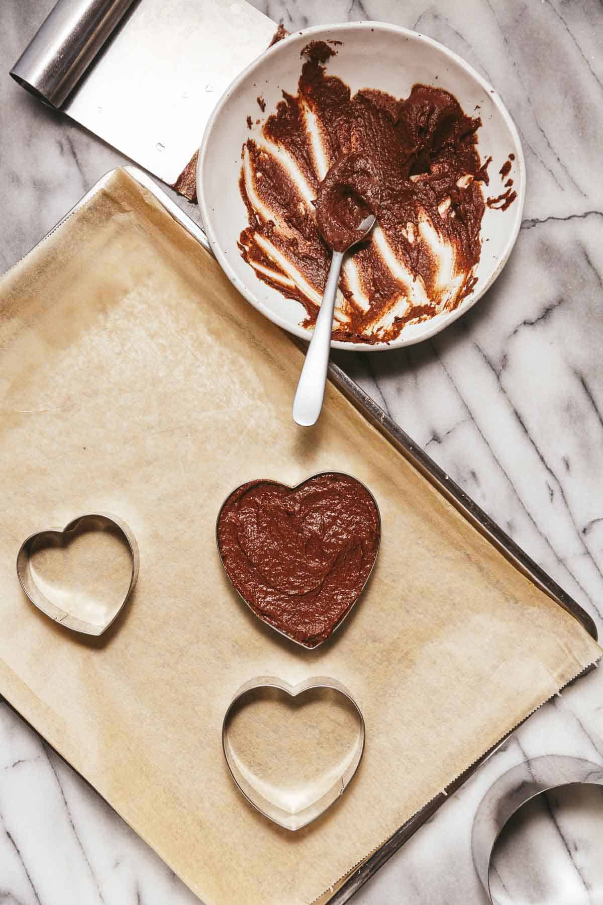 Filling heart-shaped cookie cutters with vegan chocolate orange semifreddo dessert.