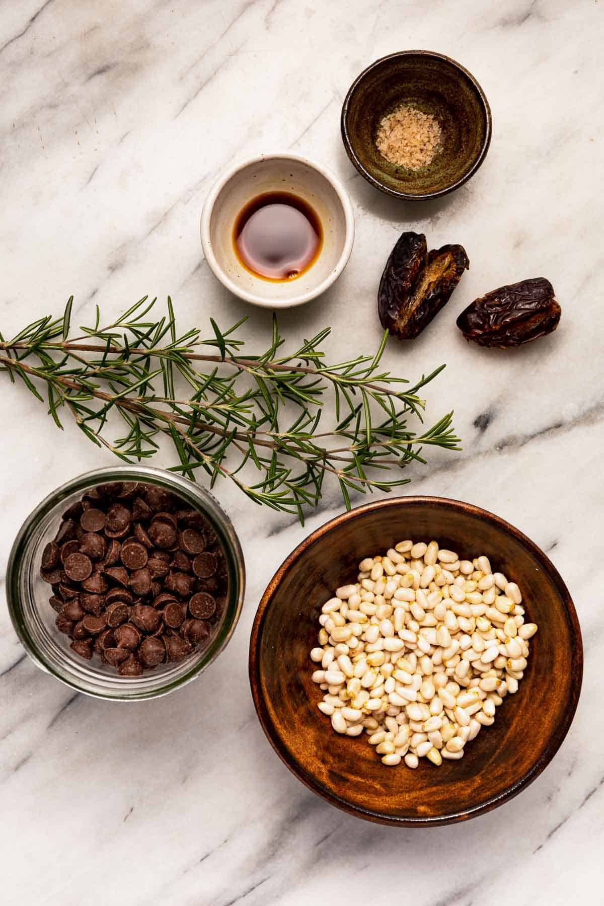 Ingredients to make homemade chocolate rosemary truffles with pine nuts and medjool dates.