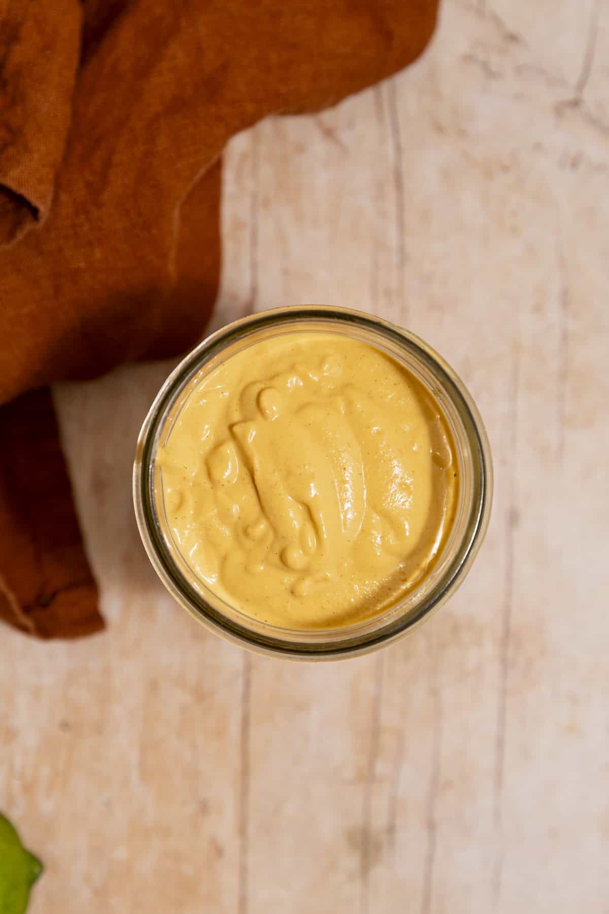 A top down vie of a jar of creamy vegan chipotle lime sauce.