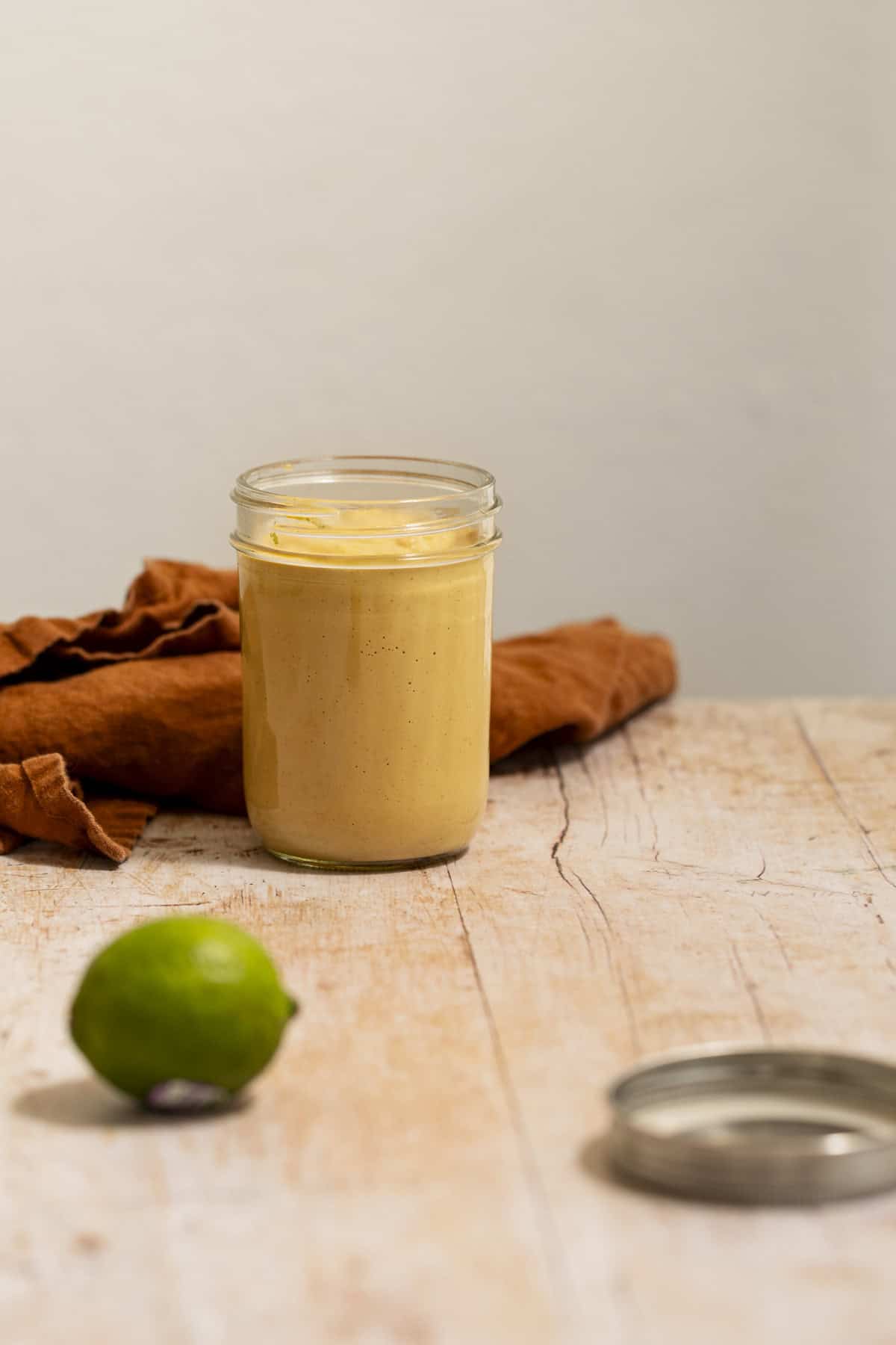 A side view of a jar of vegan chipotle lime sauce.