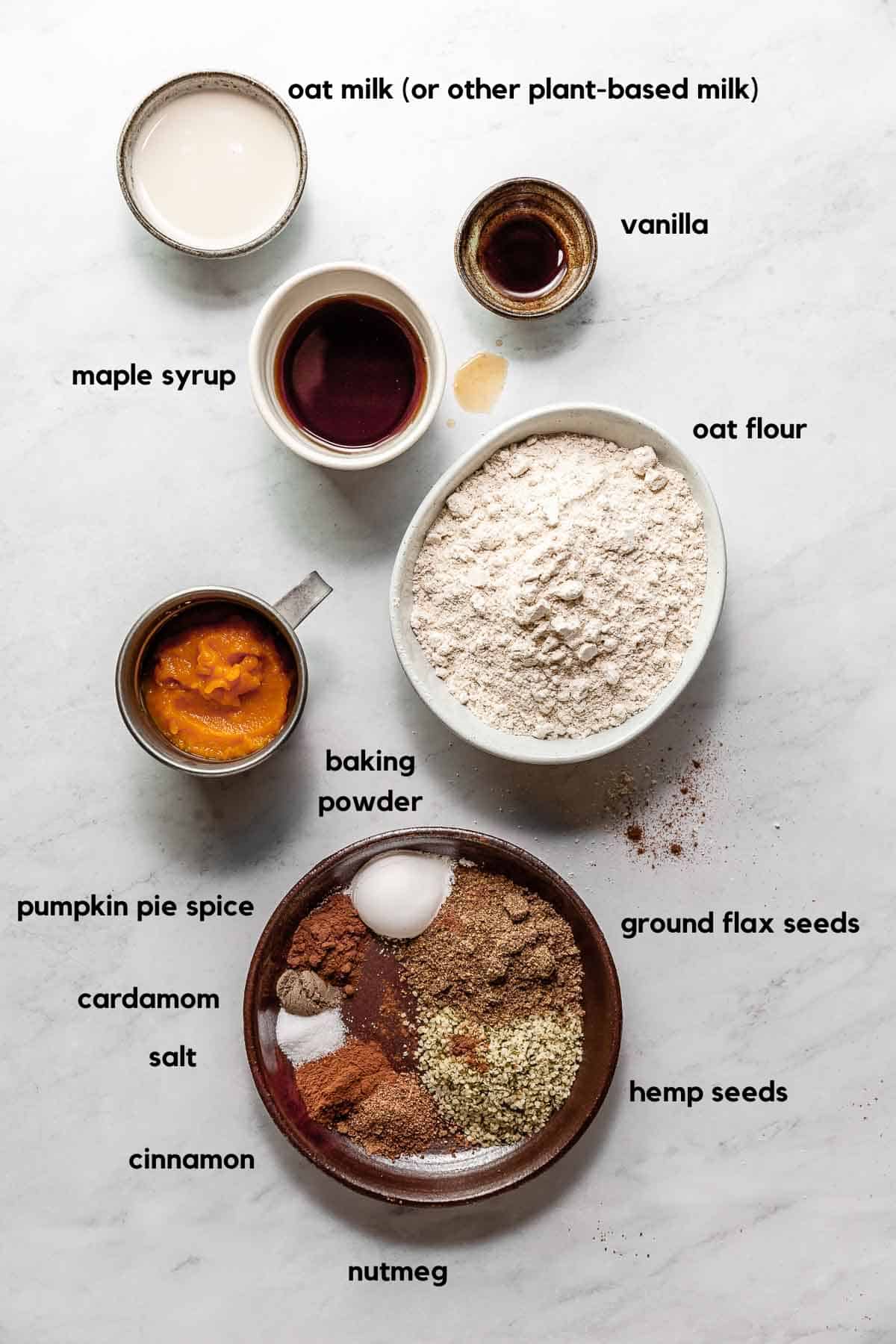 Vegan, gluten-free, and oil-free baked pumpkin doughnut ingredients labeled on a marble surface.