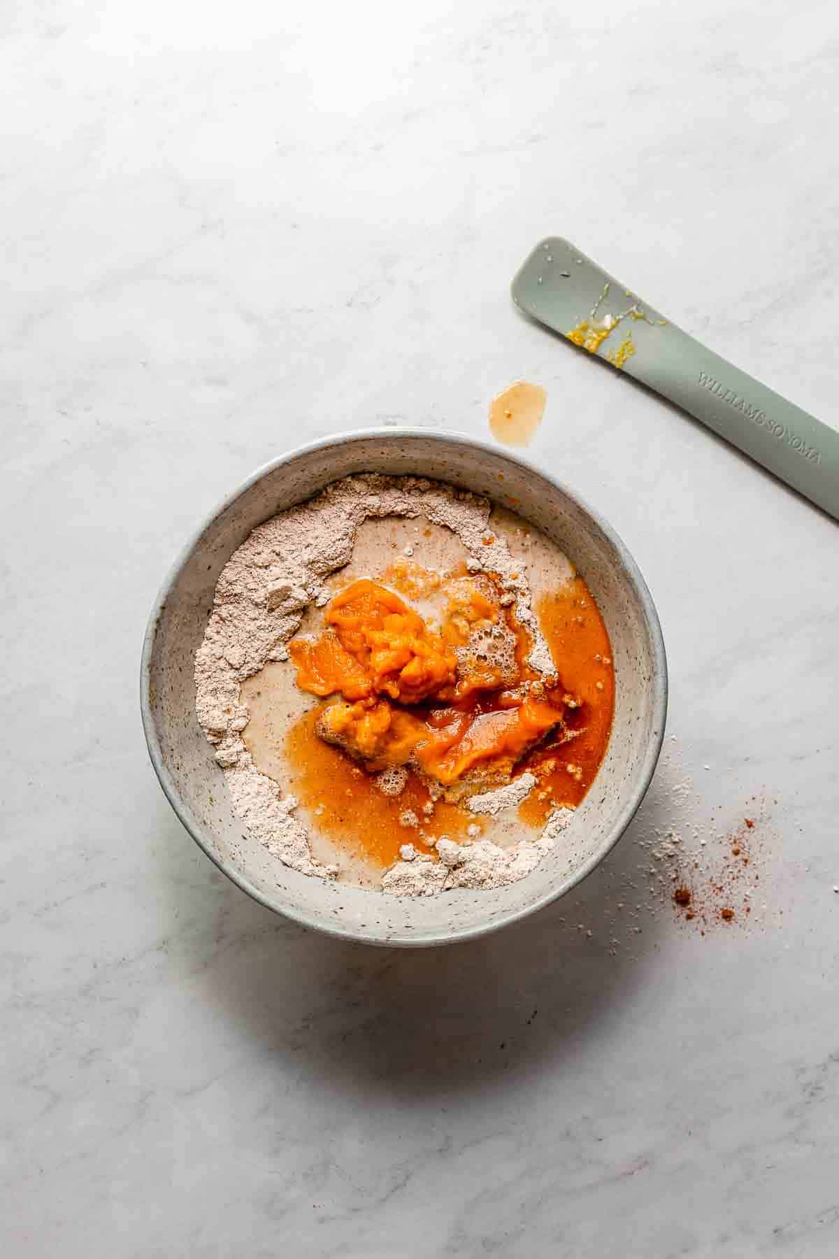 Vegan, gluten-free, oil-free baked pumpkin donut wet ingredients added to dry in a mixing bowl.