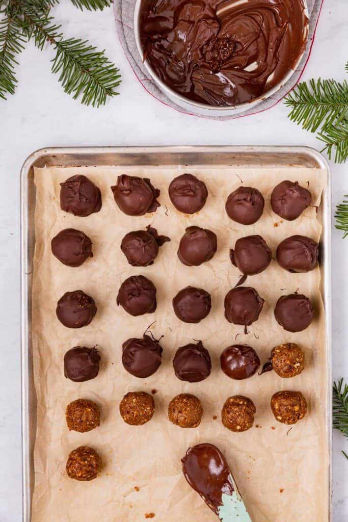 a tray of peanut butter balls, each being dipped in chocolate