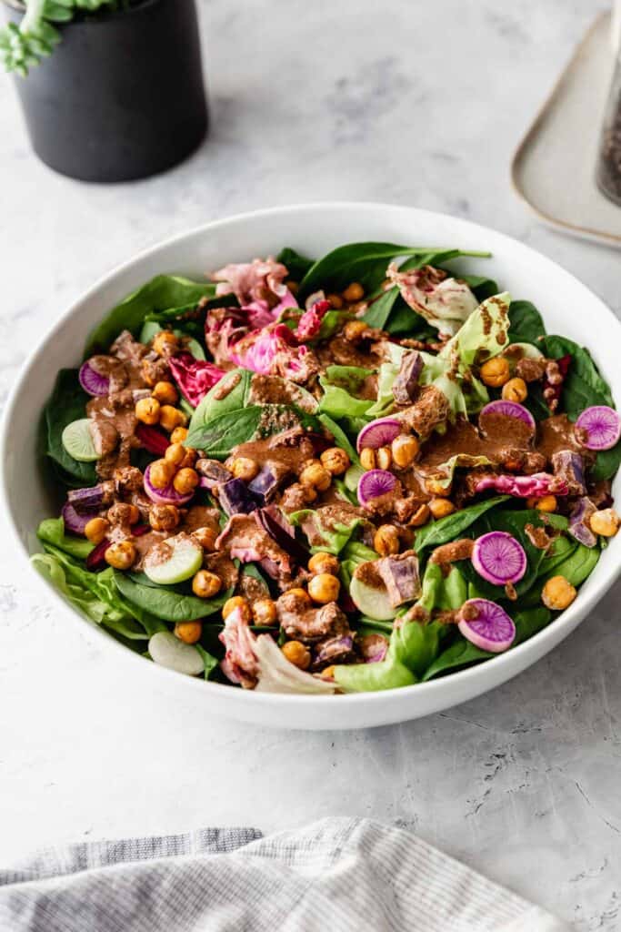 a colorful salad with tahini balsamic dressing on it