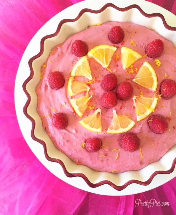 Raspberry lemon pie topped with orange and raspberries