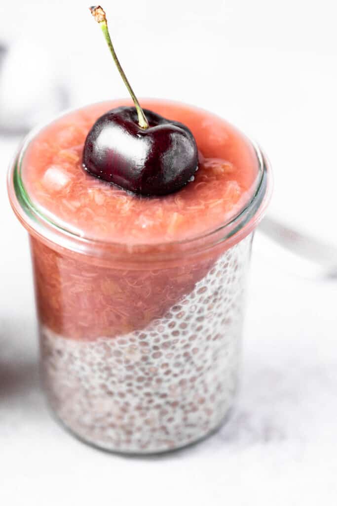 rhubarb ginger compote on chia pudding with a cherry on top