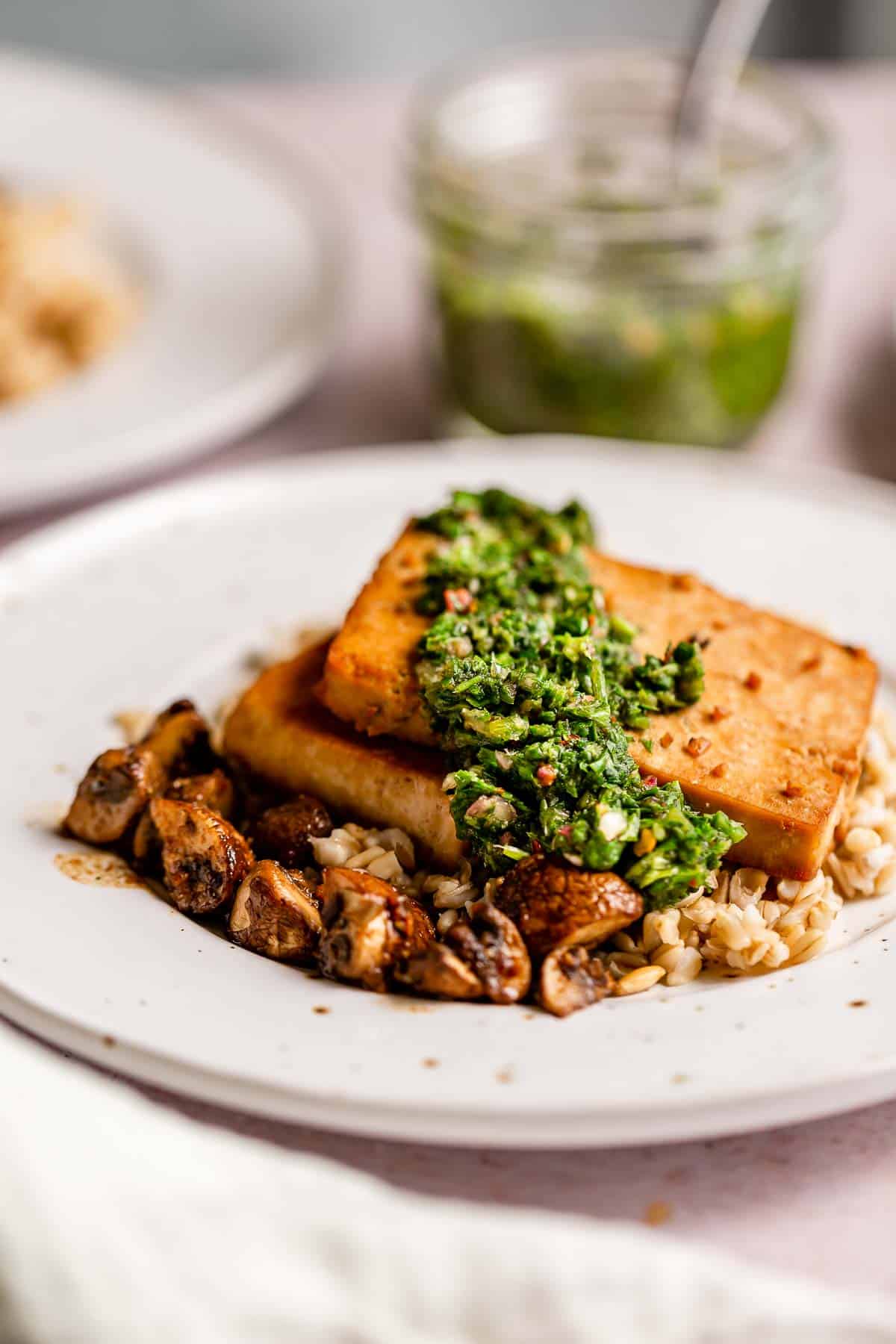 Tofu steaks over oat groats topped with chimichurri.