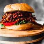 A vegan pulled mushroom burger on a wood butcher block.