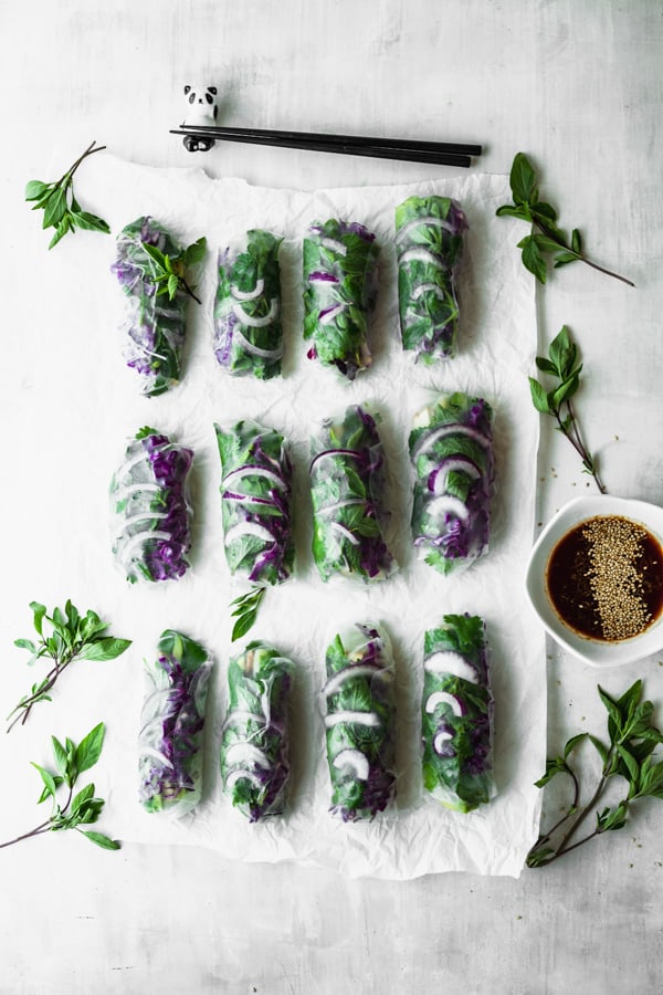 12 green and purple summer rolls on parchment paper