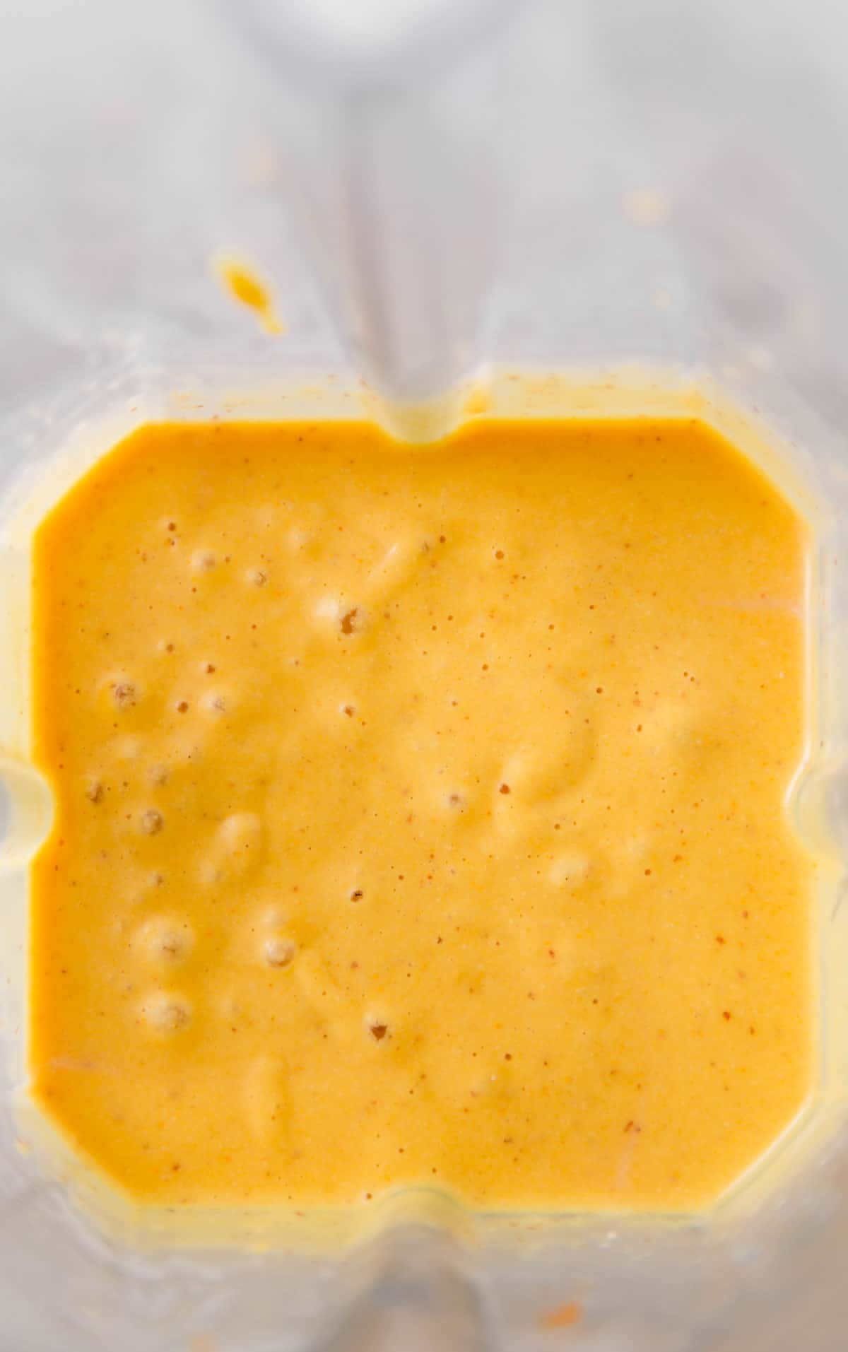 Homemade vegan cheese sauce in a clear blender.