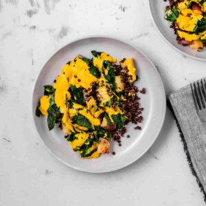 A cozy dish of cheesy potatoes, lentils, and kale next to another.