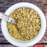 A white ramekin filled with a hemp seed blend with the title, Vegan Hemp Parmesan Recipe.