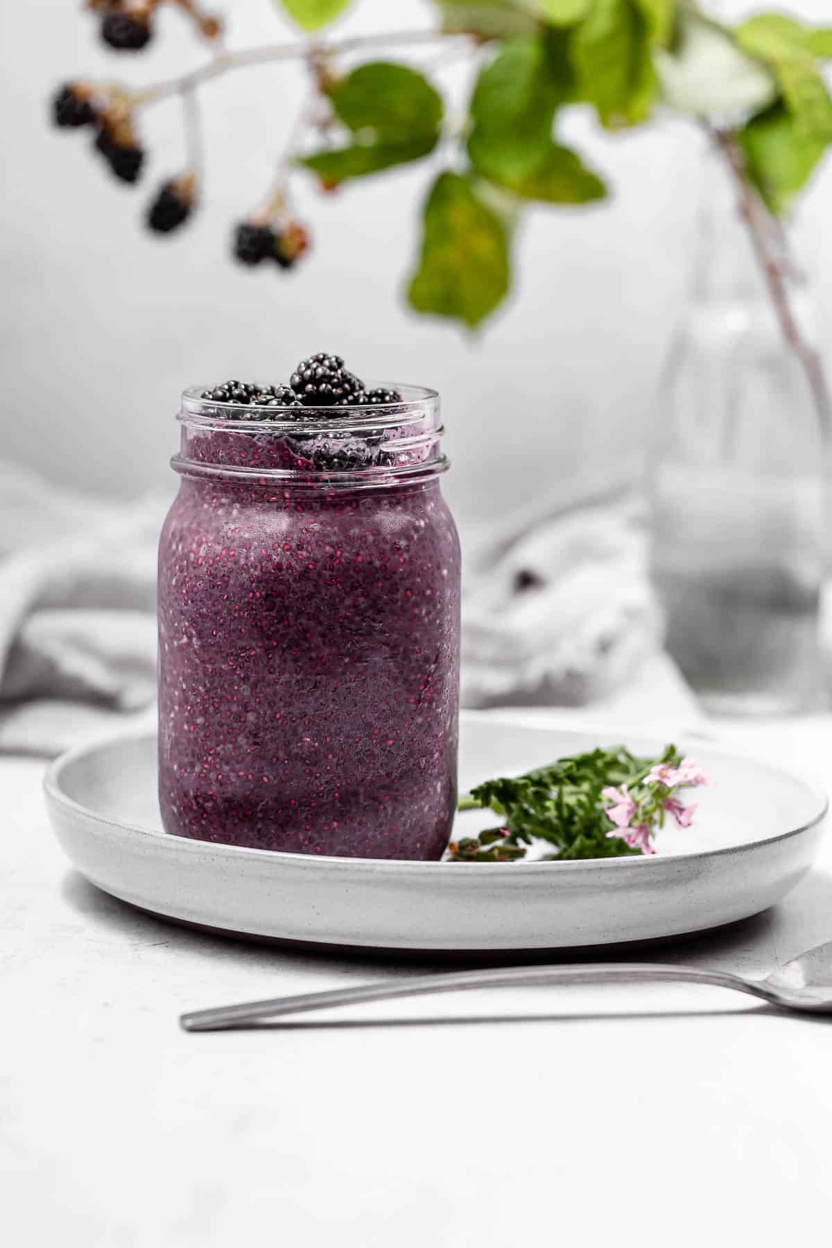 A large jar of blackberry chia pudding with blackberries on top.