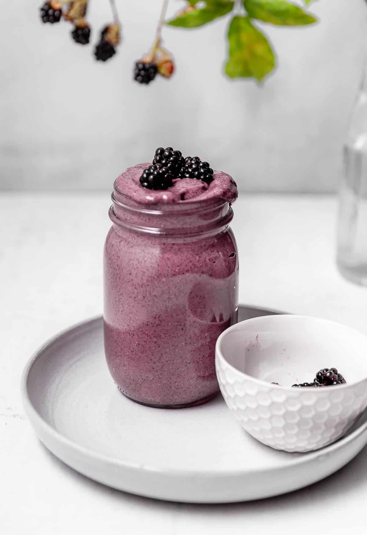 A large jar of smooth blackberry chia pudding, which has been blended.