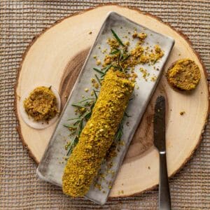 A top down view of a plated Lemon Rosemary Vegan Cheese Log.