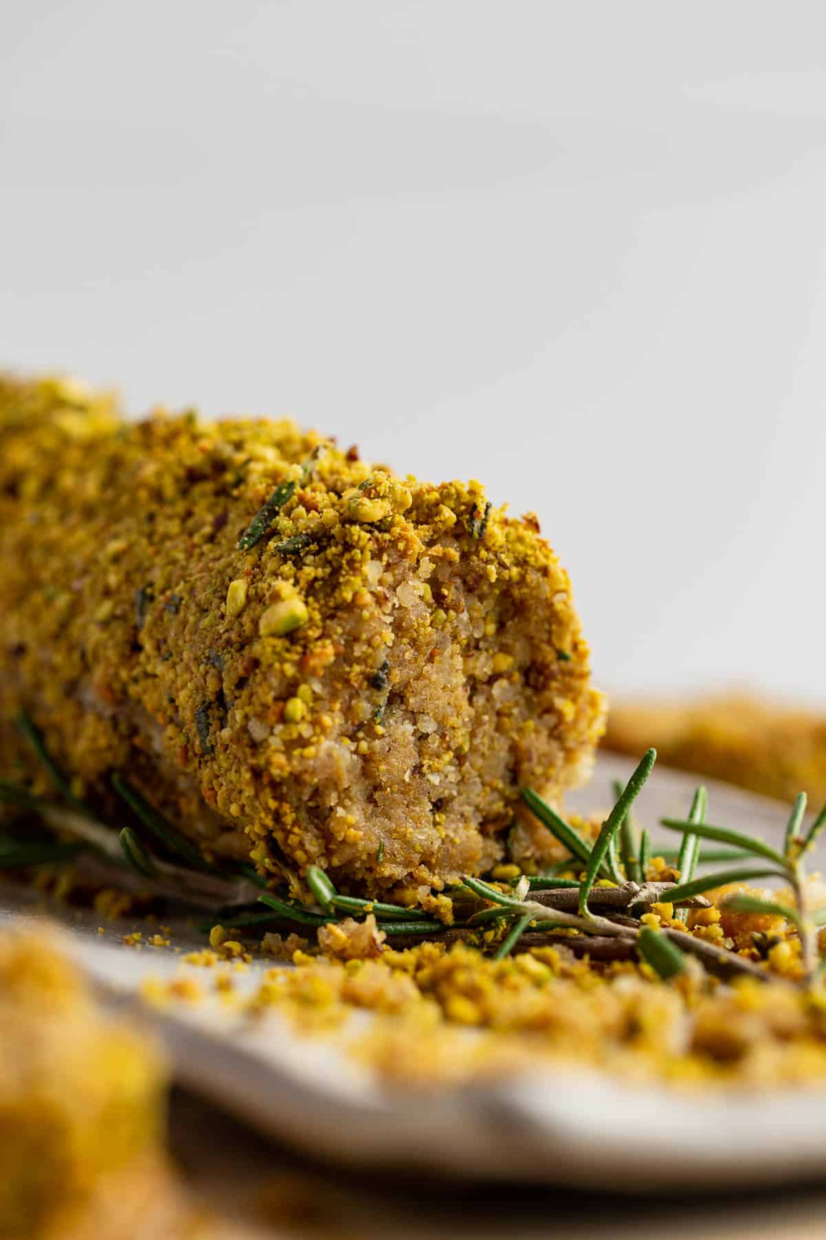 A closeup view of the front sliced end of a Lemon Rosemary Vegan Cheese Log.