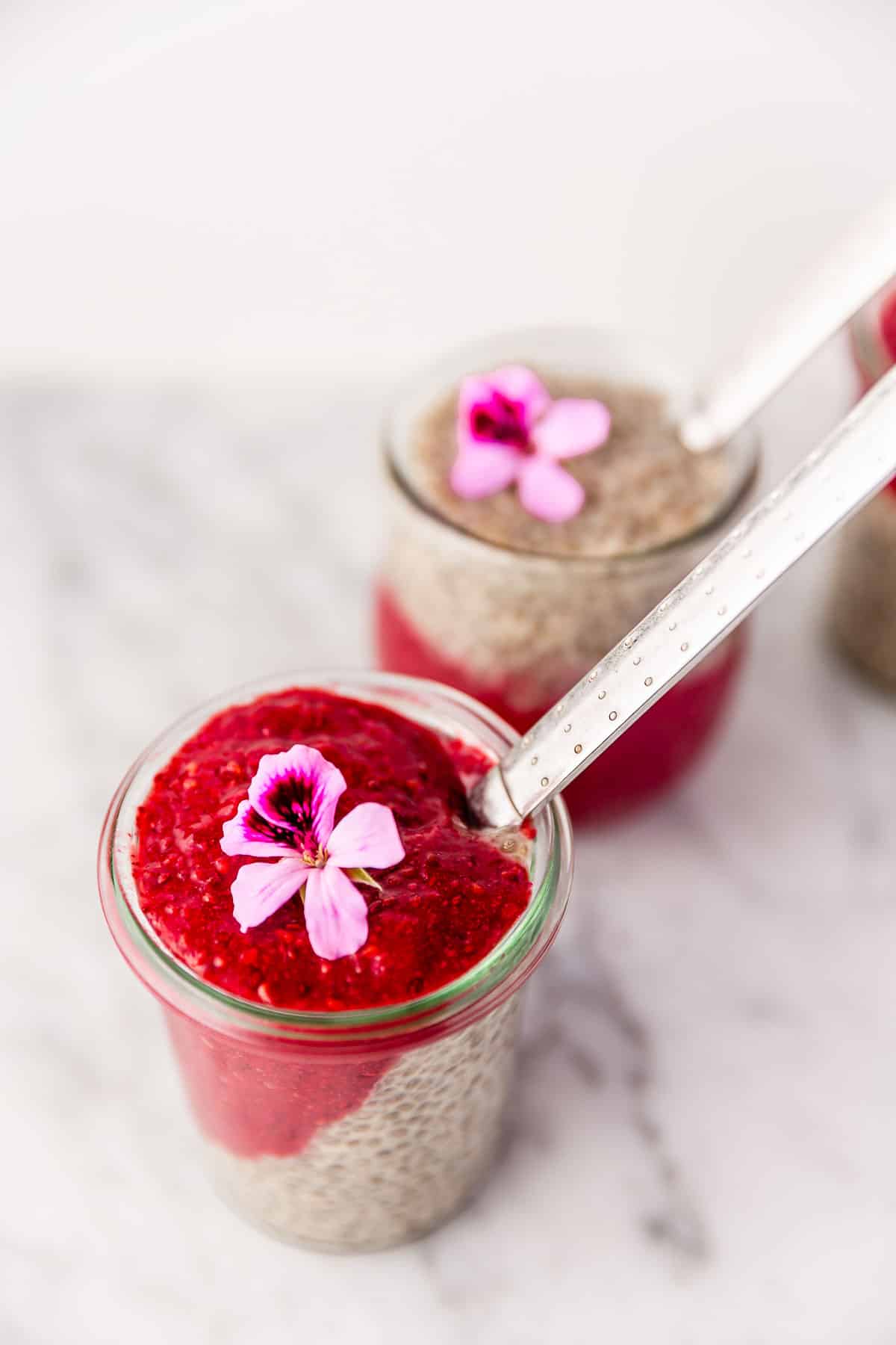 Two jars half filled with chia pudding and half chia jam.