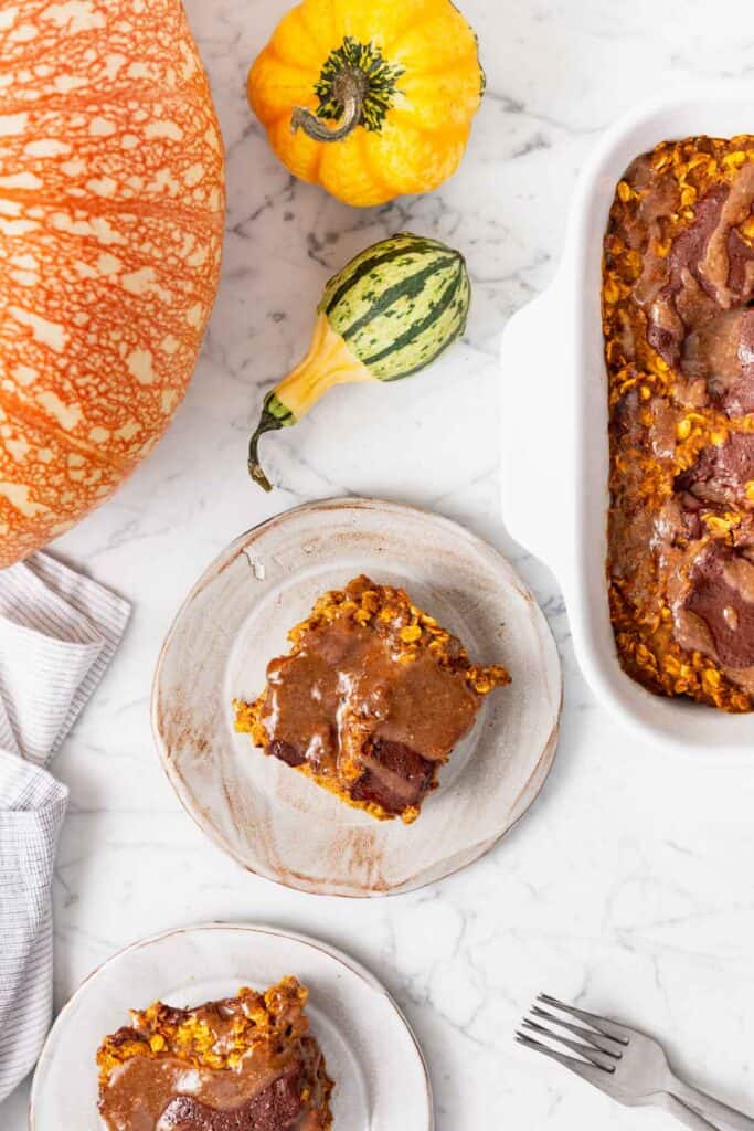 Slices of pumpkin chocolate pecan swirl baked oatmeal on a marble table