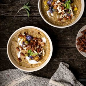 Vegan potato leek lentil stew in two big bowls with dairy-free cream and other toppings.