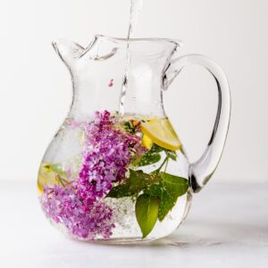 Lilac and lemons flavoring water in a pitcher