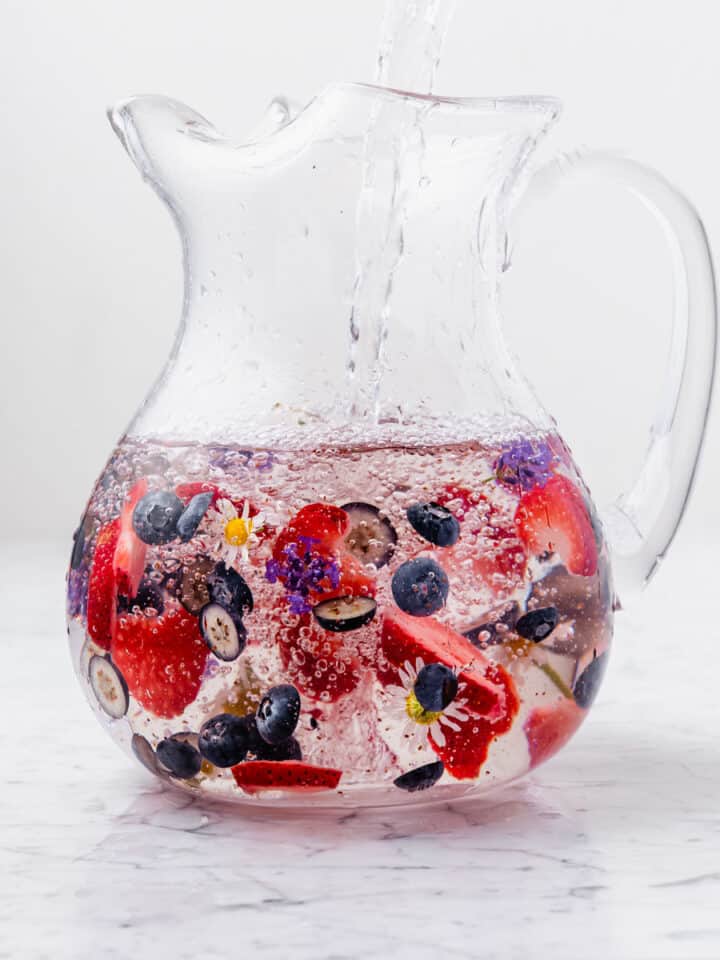 red, white, and blue drink of fruit and herbs in a water pitcher
