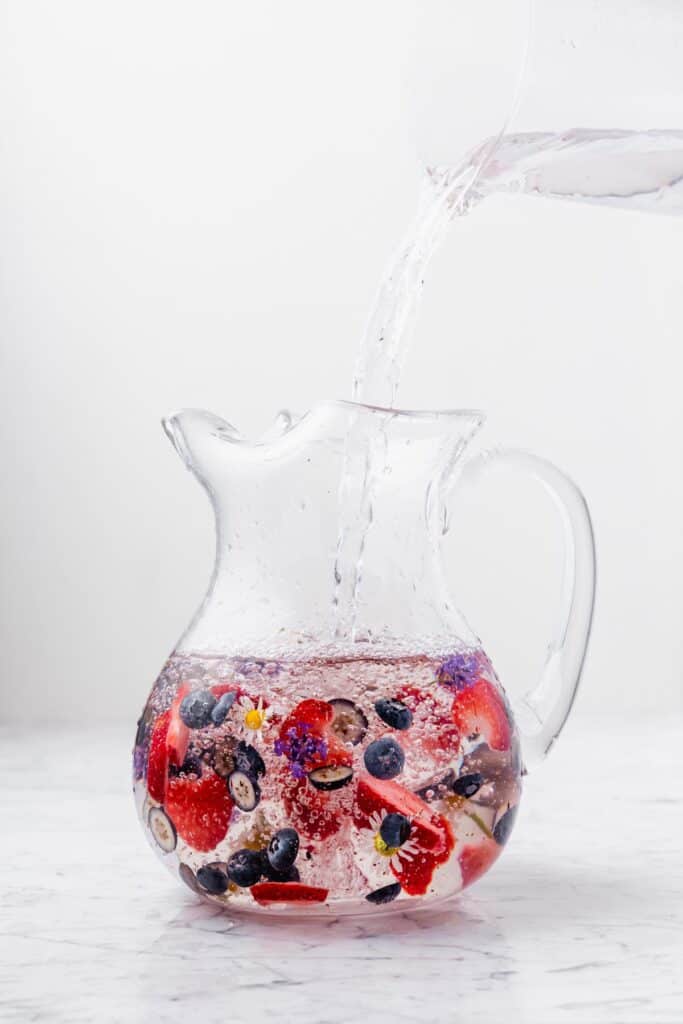 A red, white, and, blue infused water in a pitcher with natural ingredients