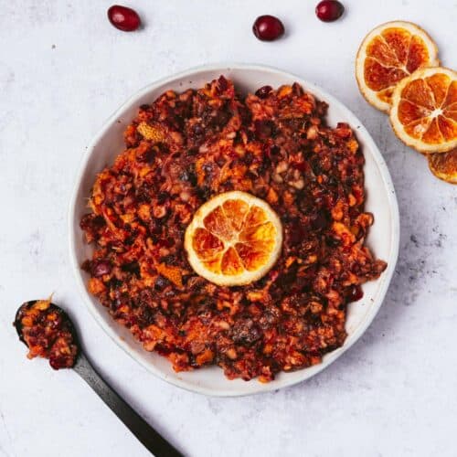 a bowl of cranberry orange satsuma relish with oven dried orange slices