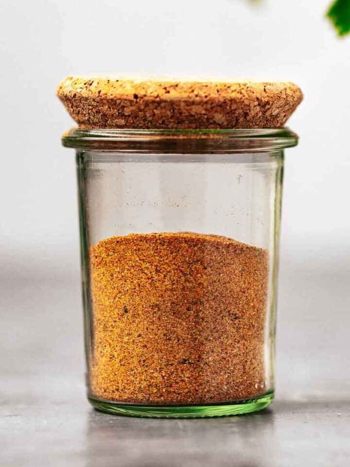 A jar of homemade french fry seasoning mix with a cork lid.