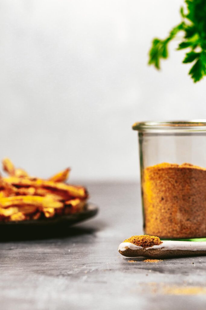 A plate of thin-cut fries next to a jar of homemade spice mix.