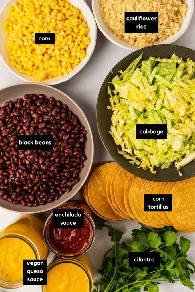 Bowls of corn, cabbage, cauliflower rice, black beans, corn tortillas, vegan cheese sauce, enchilada sauce.