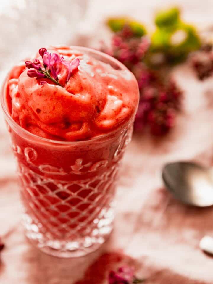 A glass filled with vegan strawberry frozen yogurt.