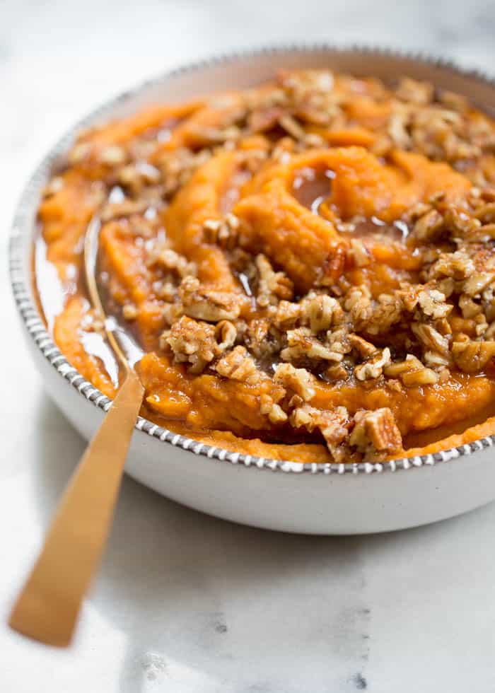 A serving bowl filled with vegan coconut whipped sweet potatoes with maple pecan drizzle.