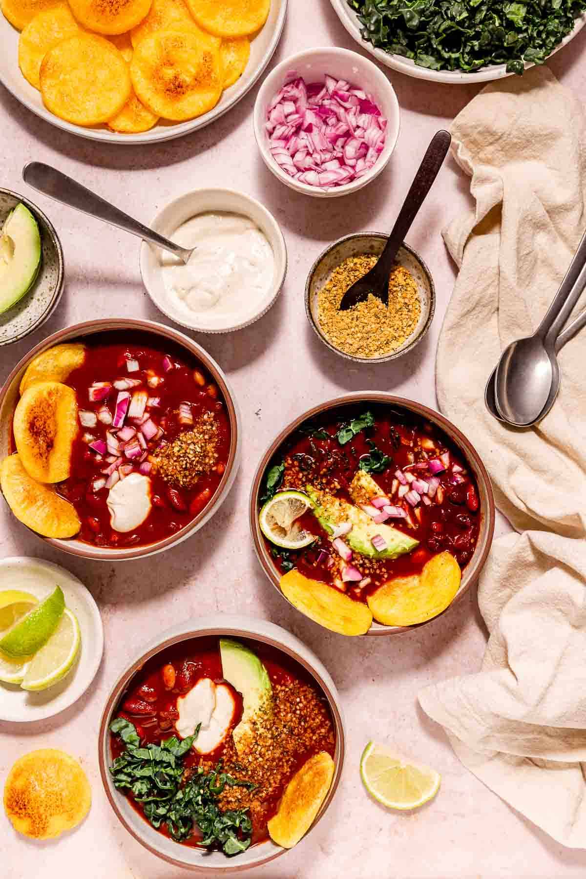 Instant Pot vegan chili with greens, polenta rounds, vegan sour cream, and smoky hemp seasoning.