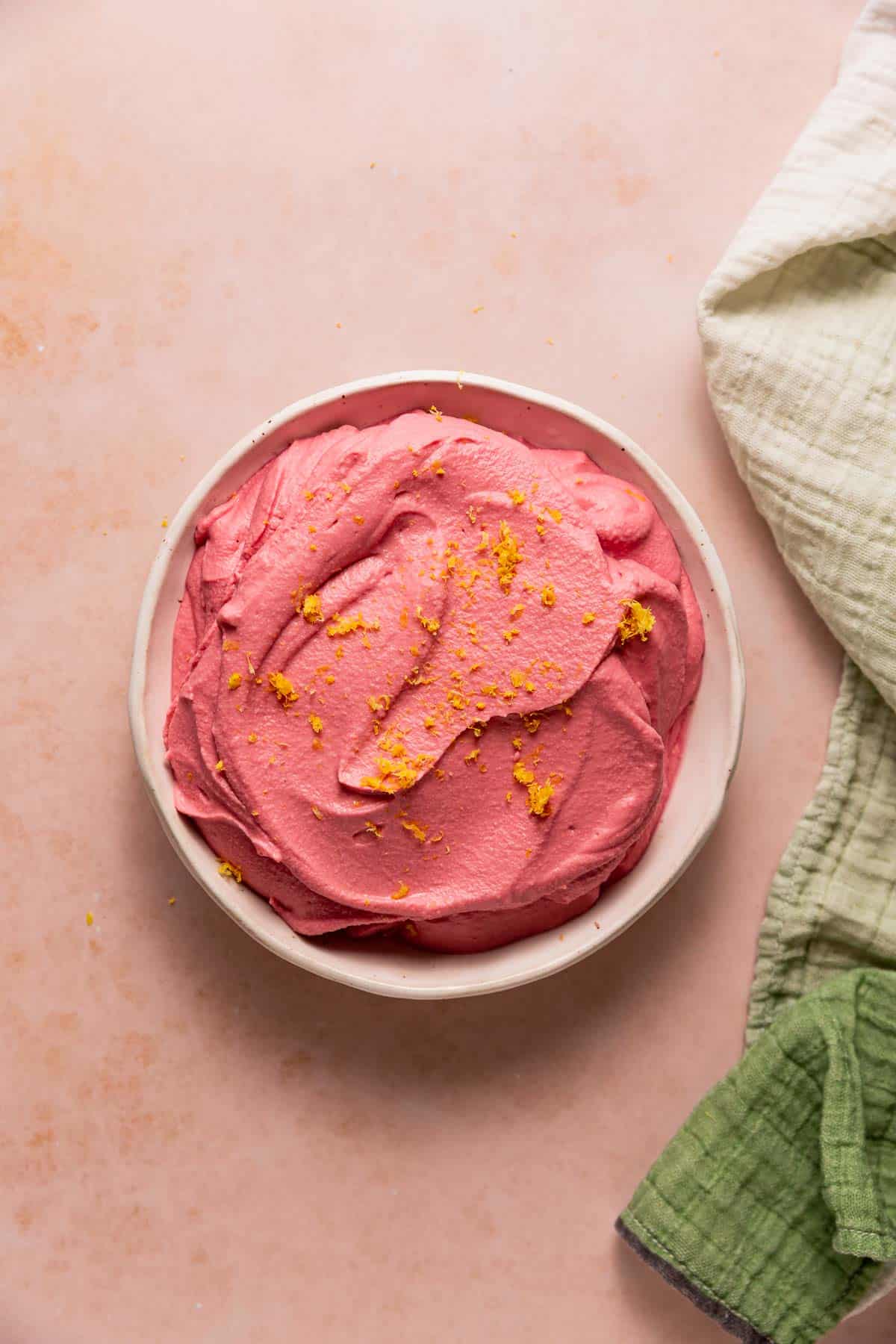 A big bowl of pink beet hummus topped with lemon zest.