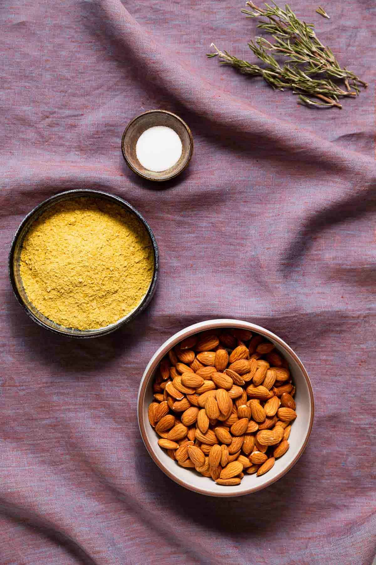 Almonds, nutritional yeast, rosemary, and salt for making vegan parmesan sprinkles.