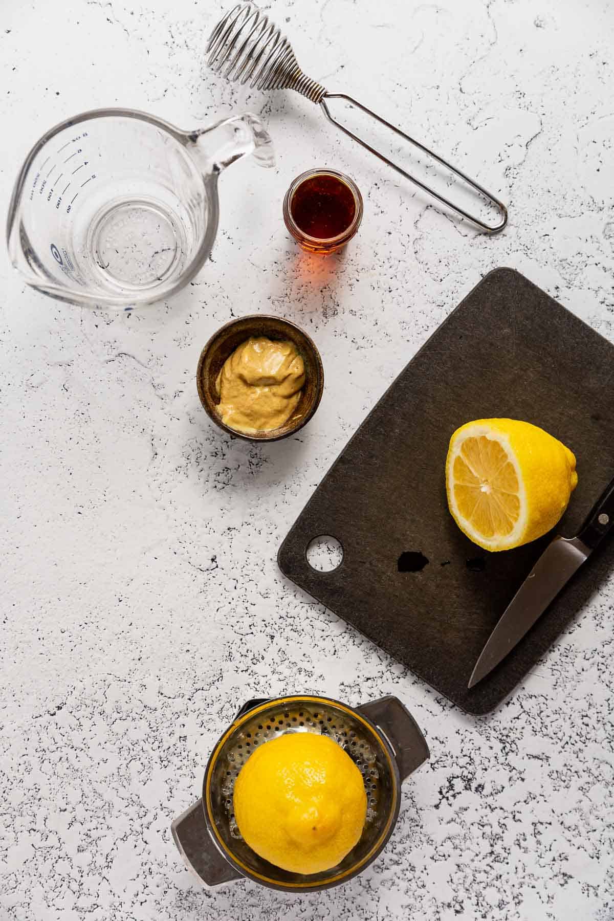 A lemon being juiced for maple dijon salad dressing.