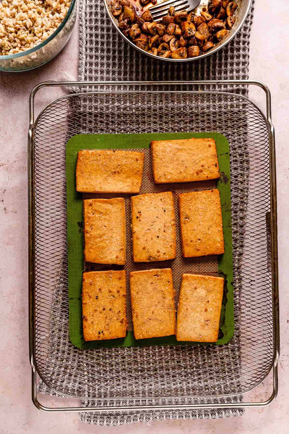 Baked tofu steaks on a baking surface.