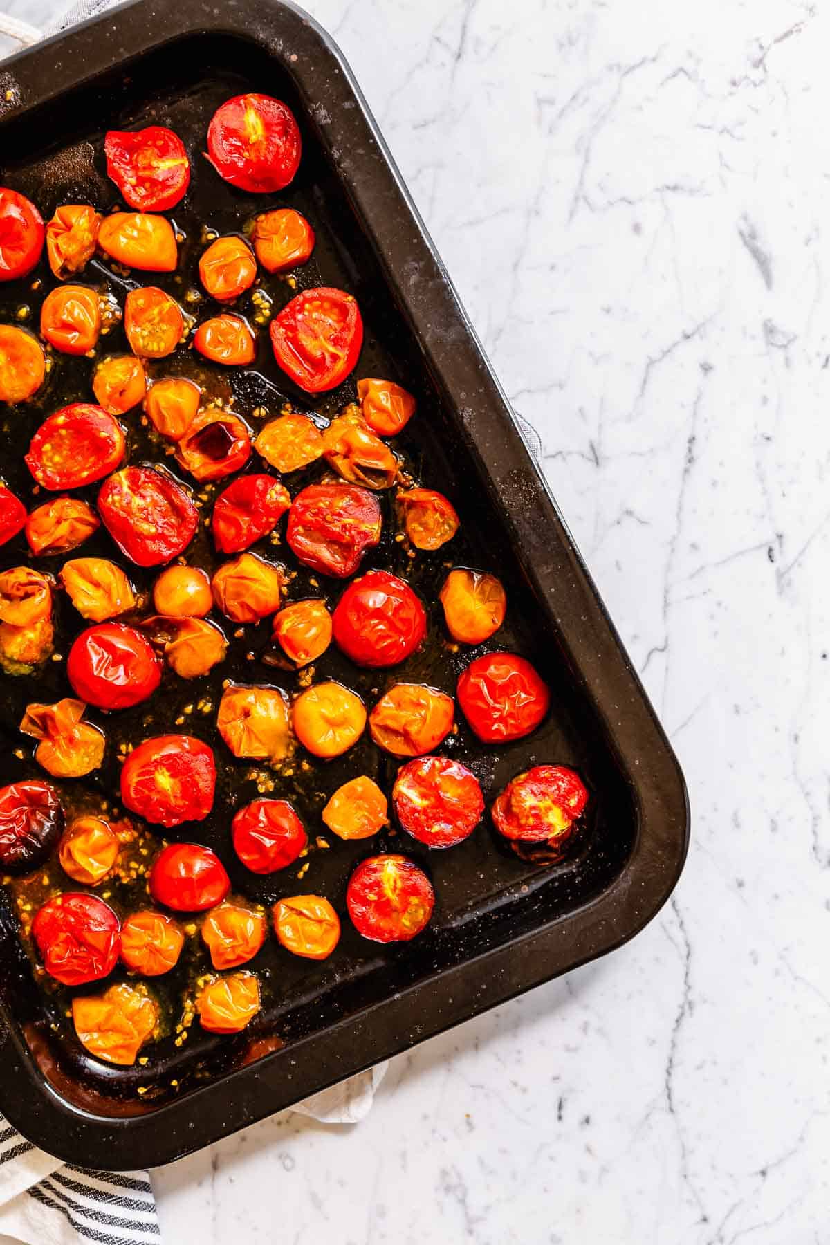 Roasted cherry tomatoes in a roasting pan.