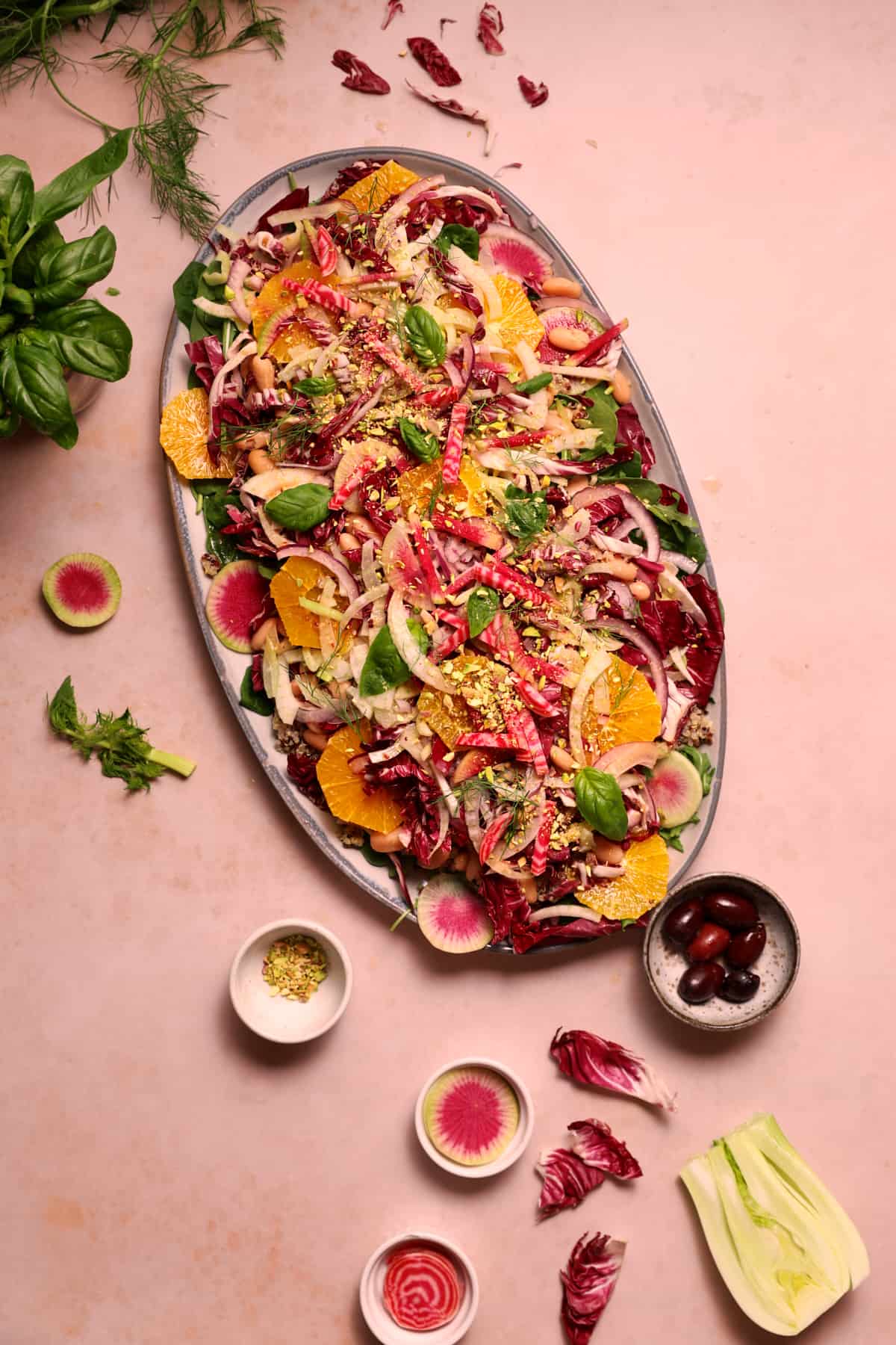An oval platter filled with a colorful vegan winter salad with oranges and radicchio.