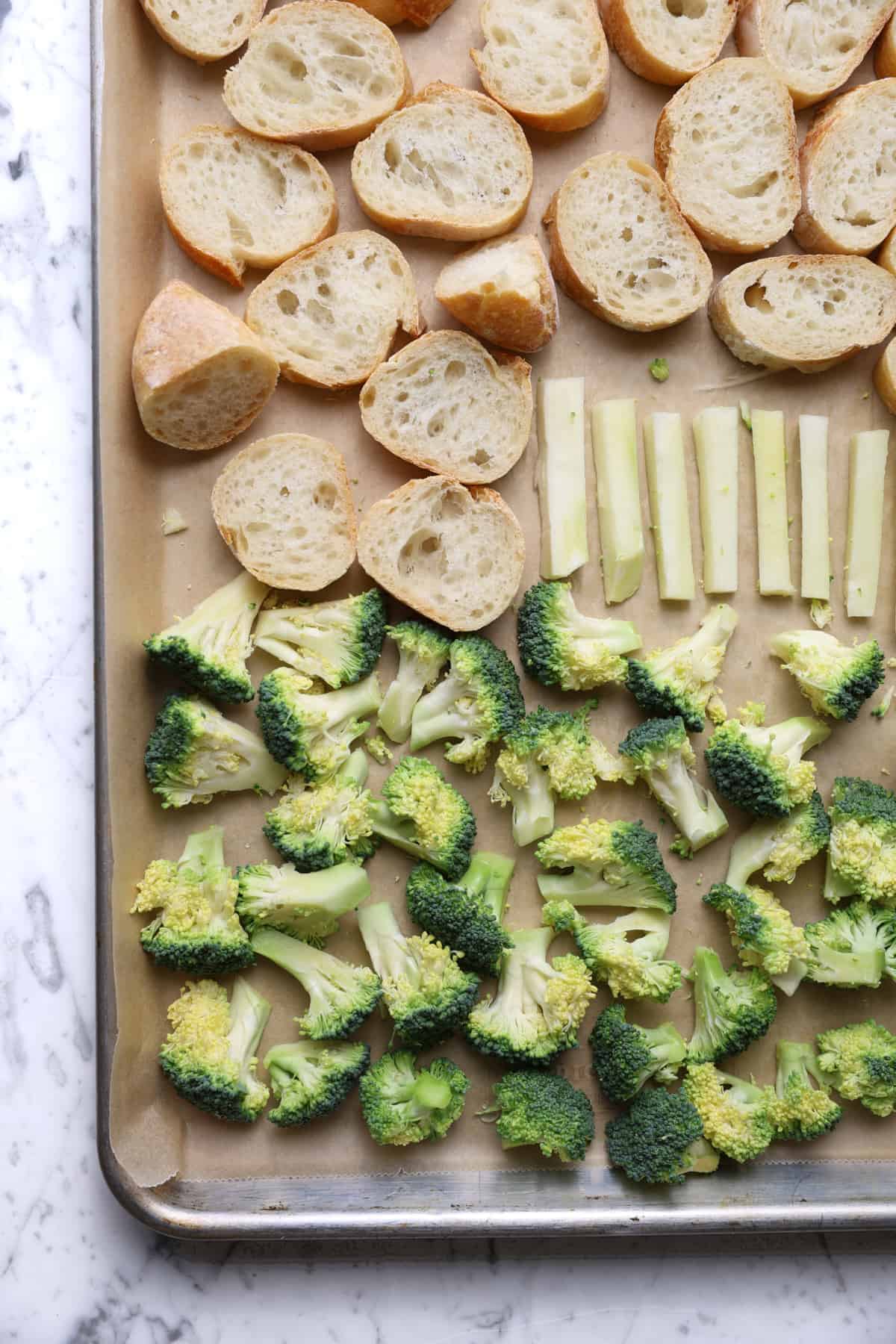 Broccoli and sourdough on a lined baking sheet.