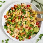 A closeup view of a large salad bowl filled with vegan street corn salad.
